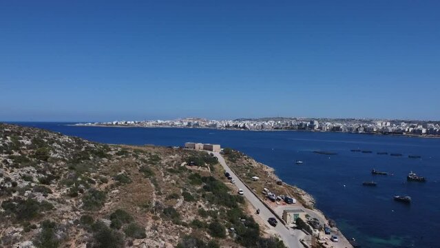 Aerial view of Mistra battery from Mistra bay. Qawra aquarioum and Bugibba promenade in the distance. . High quality FullHD footage