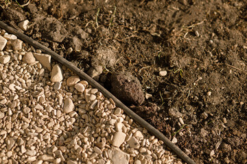 Pebbles pathway top view with edge. River stones shingle , mineral material for pathways in modern urban garden of farmhouse