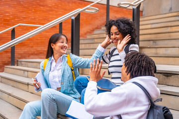 Happy multi-ethnic students sitting in the campus having fun