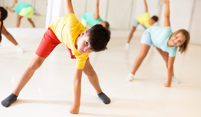 Youth boy dancing with his friends in dance studio during group training.