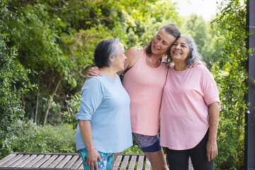 Outdoors, diverse senior female friends sharing happy moment