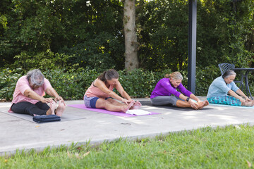 Outdoors, diverse senior female friends stretching