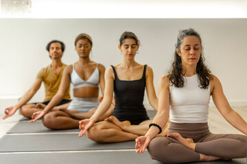 Yoga students meditating in a peaceful studio.