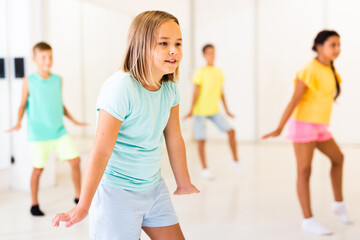 Fototapeta premium Girl and other kids dancing hip hop in dance studio