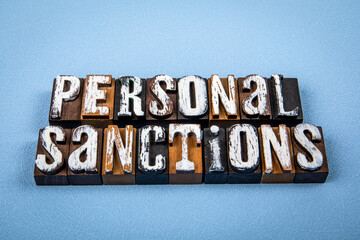 PERSONAL SANCTIONS. Wooden alphabet letter blocks on blue textured background