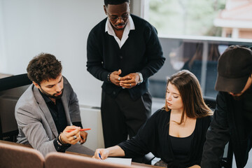 Focused group of male and female employees engaged in a business meeting at a conference table in a well-lit office.
