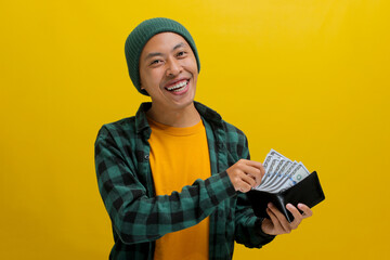 Excited Asian man, dressed in a beanie hat and casual shirt, smiles at the camera while proudly...