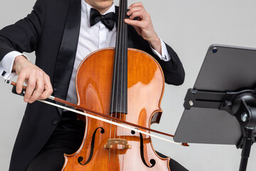 Unrecognizable male musician performing with cello and music note
