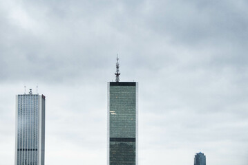 Composition of three modern glass buildings against the gray cloudy sky of Warsaw, Poland