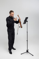 Full length of musician playing violin performing concert