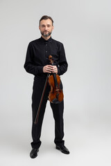 Adult man in black shirt playing violin