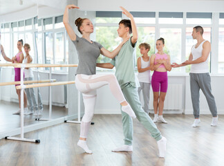 Boy and girl in pair train to perform ballet dance during rehearsal in studio. Young ballet dancers...