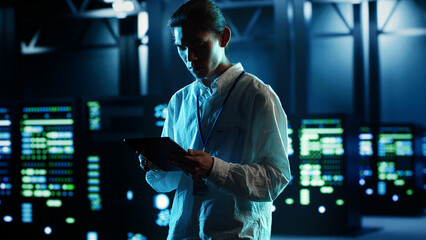 Asian man strolling through data center server rows providing processing and memory resources for...