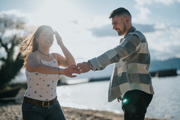 A cheerful young couple enjoying a dance on a beach during their vacation, expressing happiness and...