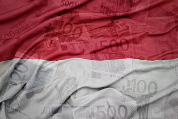 waving colorful national flag of indonesia on a euro money banknotes background. finance concept.