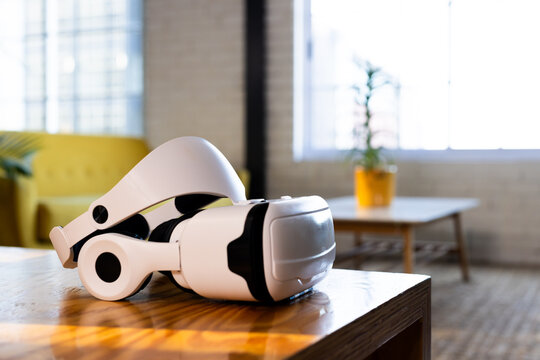 At office, white virtual reality headset resting on table in bright room