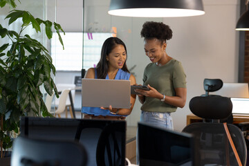 At office, diverse female business colleagues discussing work