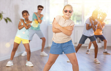 Girl in sun glasses performs choreographic exercises and teaches energetic mobile social dance...