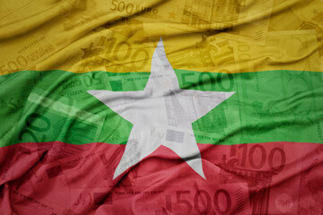 waving colorful national flag of myanmar on a euro money banknotes background. finance concept.