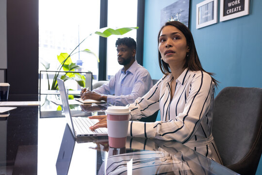 A middle-aged Black couple focusing on screens at office