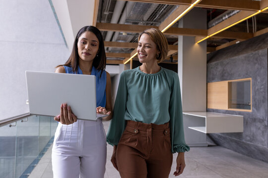Diverse team members walking together at office, sporting straight hair