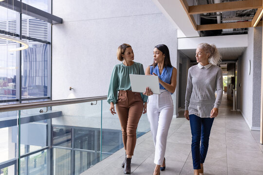 Diverse team of middle-aged Caucasian and biracial pros walking at office