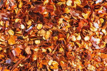 Dried red chili flakes with seeds background. Chopped chilli cayenne pepper. Spices and herbs