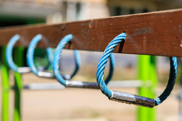 A row of blue and silver ropes hanging from a wooden beam