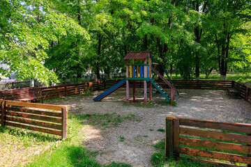 A playground with wooden fence and a wooden play structure