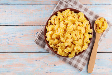 Creste di Gallo Pasta with Wooden Spoon on Wooden Table, Top View, Copy Space
