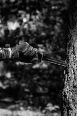 A military knife and a hand in tactical gloves holding it. Military affairs, tactical equipment....