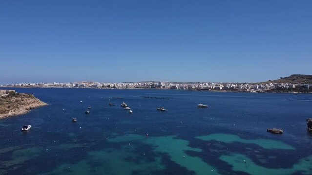 Aerial view of the calm sea with boats and fishing farms from Mistra bay, Malta, may 2024. High quality FullHD footage
