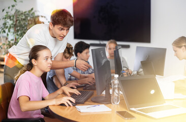 Curious underage girl engaged in IT training with help of teacher in computer courses