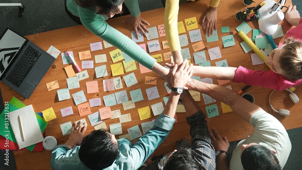 Aufkleber top down view of designer standing at meeting with sticky note and putting hand together. aerial vie