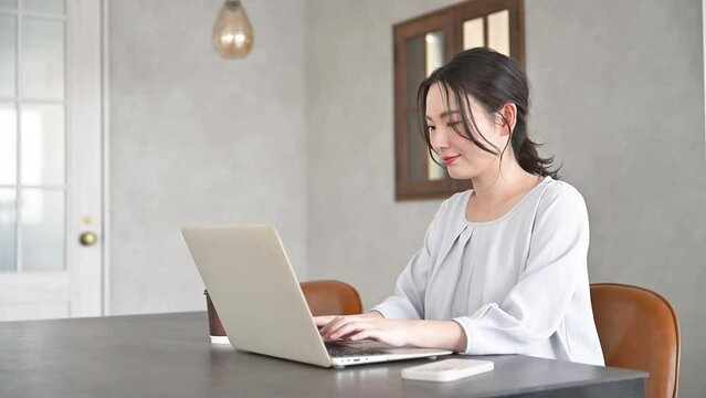 ビジネスオフィスでパソコンを操作する若い女性　画面を見てタイピングをする動画
