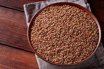 Organic Dry Buckwheat Grains on Brown Wooden Background, Copy Space
