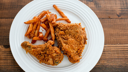 Crispy fried chicken and golden potato fries on a white plate