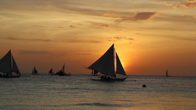 sailboats sailing on a tropical sea at sunset viewed from the beach, tropical, ocean, water, waves, beach, sailboats, sunset