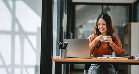 Businesswoman takes pleasure in a coffee break at her desk, amidst a session of productive work.