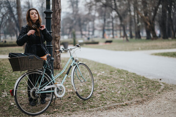 An elegant and confident young woman rests with her vintage bicycle in a serene park setting,...