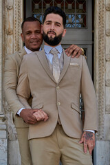 Portrait of a gay couple celebrating their love, they are newlyweds. One of the bride and groom has a ring on his finger showing their love. Diversity, lgbt community