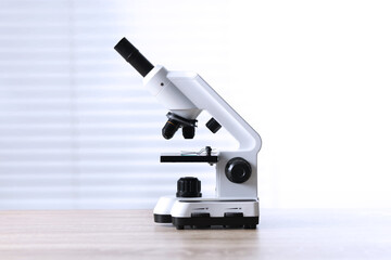 Modern medical microscope on wooden table indoors