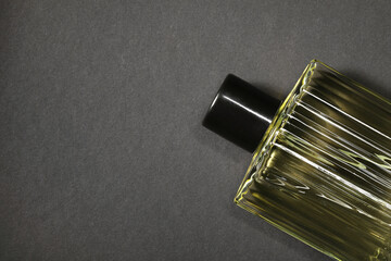 Luxury men`s perfume in bottle on black background, top view. Space for text