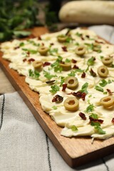 Fresh butter board with cut olives, sun-dried tomatoes and parsley on table, closeup