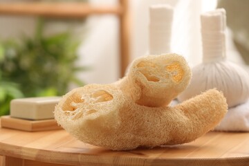 Loofah sponges on wooden table indoors, closeup