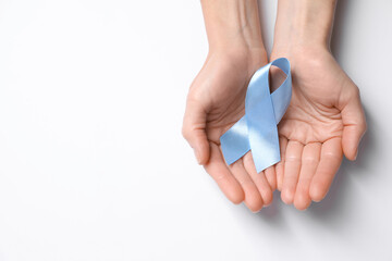 International Psoriasis Day. Woman with light blue ribbon as symbol of support on white background, top view. Space for text