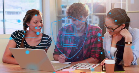 Image of security padlock icon against diverse photographers discussing over photos at office