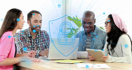 Image of security padlock icon against diverse colleagues discussing over a laptop at office