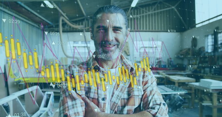 Image of orange graph processing over portrait of happy caucasian male carpenter in workshop