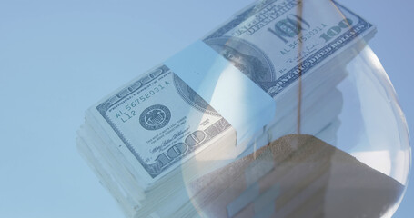 Image of american dollar banknotes over hourglass